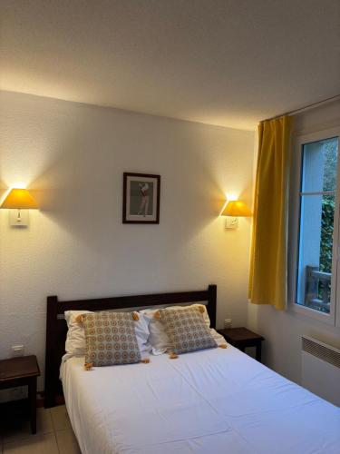 a bedroom with a bed with two pillows and a window at Chez Adelaïde in Levernois
