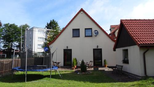 a white house with a red roof at Letni Wiatr Willa Retro in Łeba