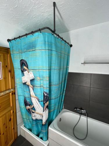 a bathroom with a shower curtain with a cat on a boat at EcoLodge Bungalow in Oesterdeichstrich