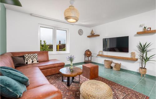 a living room with a couch and a tv at Beautiful Home In Banjol With Sauna in Banjol