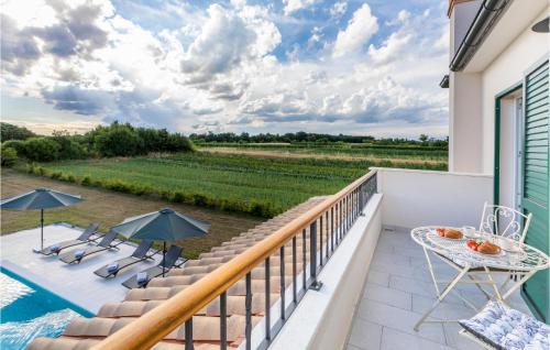 un balcone con tavolo e sedie e una piscina di Amazing Home In Zminj a Benčići