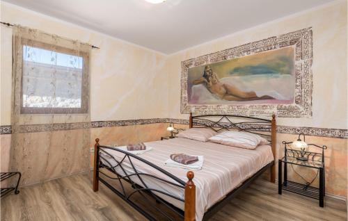 a bedroom with a bed with a painting on the wall at Gorgeous Home In Zgaljici With Sauna in Žgaljić