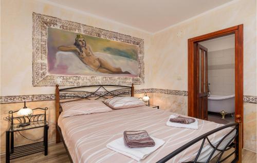 a bedroom with a bed with a painting on the wall at Gorgeous Home In Zgaljici With Sauna in Žgaljić