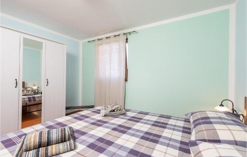 a bedroom with a bed with a checkered blanket at Gorgeous Home In Zgaljici With Sauna in Žgaljić