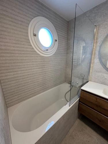 une salle de bain avec une baignoire et une fenêtre dans l'établissement Air conditioned apartment 78 m2, Terrace 50m2, à Paris