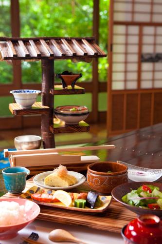 une table recouverte de assiettes de nourriture et de bols dans l'établissement Hatago Kayausagi, à Hita