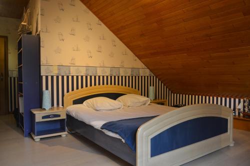 a bedroom with a bed with a wooden head board at La Maison du Bonheur in Gouvy