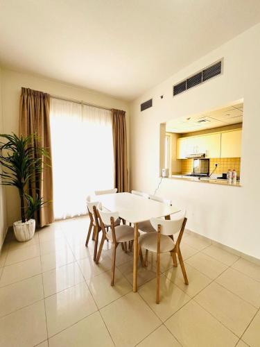 a dining room with a white table and chairs at Hala Holiday Homes- Bab Al Bahr Residence, Al Marjan Island in Ras al Khaimah
