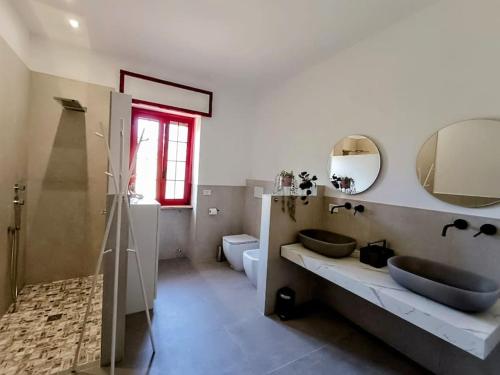 a bathroom with two sinks and a mirror at Villa Vento del Sud in Villa Castelli
