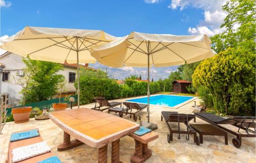 une terrasse avec une table, des parasols et une piscine dans l'établissement Amazing Home In Malinska With Kitchen, à Malinska
