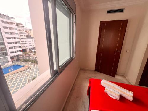 a room with a red chair and a window at Family apartment NZ in Tangier