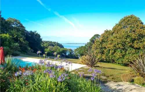 un jardín con flores y un lago al fondo en 1 Bedroom Lovely Home In Concarneau, en Concarneau