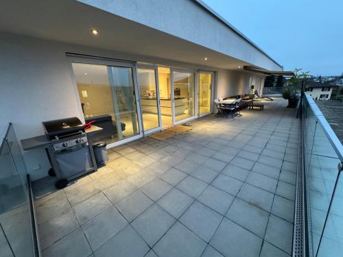 an outdoor patio with a grill on a building at Attika Loft Wohnung 3.5 Zi. 110m2 Neu Bau in Obergösgen