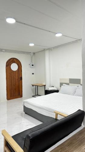 a bedroom with a large bed and a wooden door at Megun 10 L in Bangkok