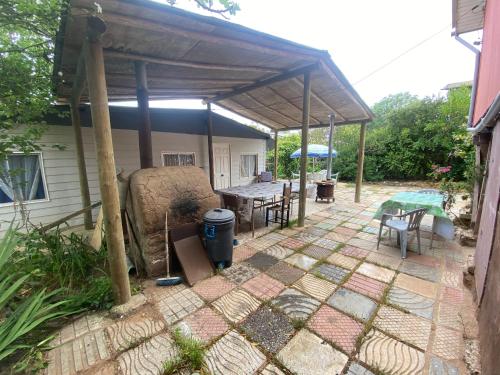a patio with a table and chairs under a pavilion at CABAÑA EL QUISCO in El Quisco