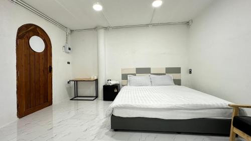 a bedroom with a large bed and a wooden door at Megun 10 L in Bangkok