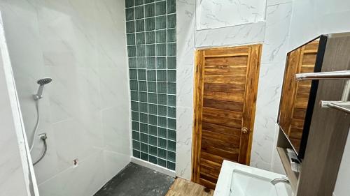 a bathroom with a toilet and a shower with green tiles at Megun 10 L in Bangkok