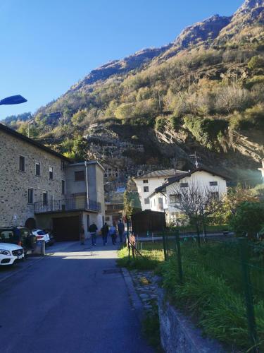 a mountain with houses and people walking down a street at Residenza Le Torri in Tirano