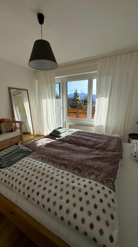 a bedroom with a large bed with a large window at Appartement 4.5 pièces Crans-Montana in Lens