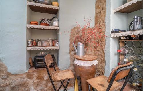 a kitchen with two chairs and a table and shelves at Gorgeous Home In El Colmenar With Wifi in El Colmenar