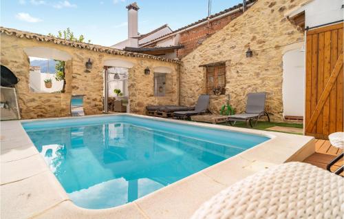 a swimming pool in front of a stone house at Gorgeous Home In El Colmenar With Wifi in El Colmenar