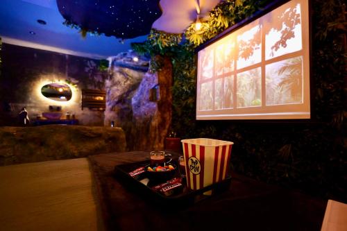 a room with a table with a drink and popcorn at Love room Piccola casa côté Forêt in La Verpillière