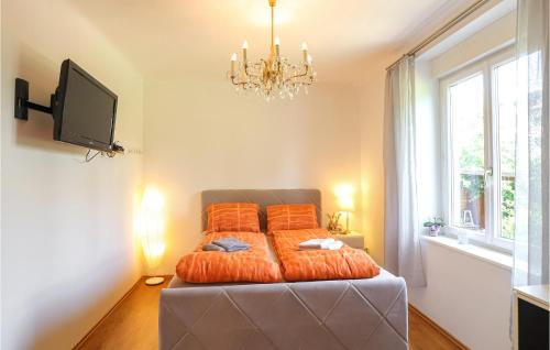 a bedroom with a bed with orange pillows and a tv at Ferienhaus In Deutschlandsberg in Deutschlandsberg