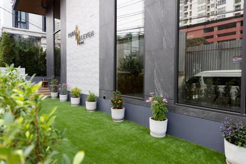a row of potted plants in front of a building at Pure Eleven Hotel Bangkok in Makkasan