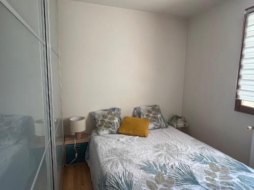 - une chambre avec un lit doté d'un oreiller jaune dans l'établissement Charmant 3 pièces proche du métro lignes 7-14, du centre ville et de l'Institut Gustave Roussy IGR - NETFLIX - PARKING, à Villejuif