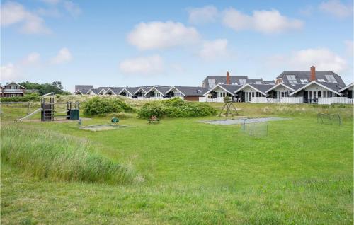 a playground in a field with houses in the background at Amazing Home In Rømø With Kitchen in Havneby
