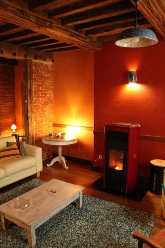 Una sala de estar con chimenea y un sofá. en L'épicurien, en Doische