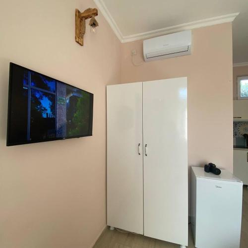a room with a white cabinet and a tv on the wall at Guest House Deme in K'obulet'i