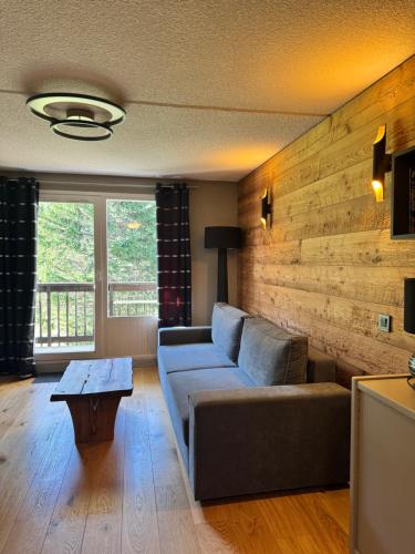 un salon avec un canapé et une table dans l'établissement Superbe studio de montagne, au pied des pistes de ski, classé 3 étoiles, à La Morte