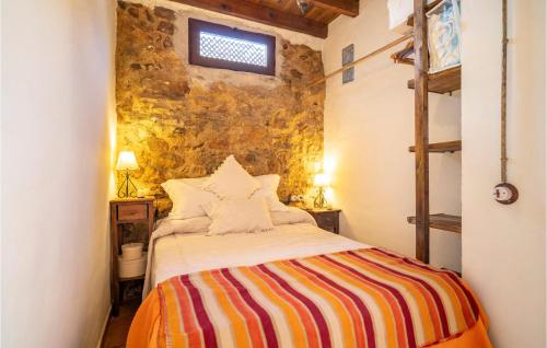 a bedroom with a bed with a colorful striped blanket at Gorgeous Home In El Colmenar With Wifi in El Colmenar