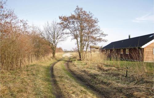 a dirt road next to a house and a barn at Holiday Home Vibelunden Rødby V in Kramnitse