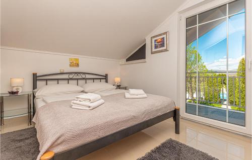 a bedroom with a bed and a large window at Two-Bedroom Holiday Home In Kijevo in Kijevo