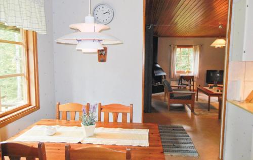 a dining room with a table and a clock on the wall at Gorgeous Home In Gislaved With Wifi in Våthult