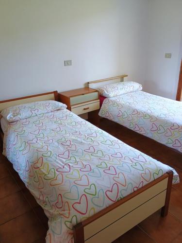 two twin beds in a room with at Palazzina in Urbania