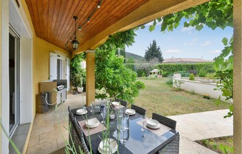 a patio with a dining table and a view of a yard at Cozy Home In Malataverne in Malataverne