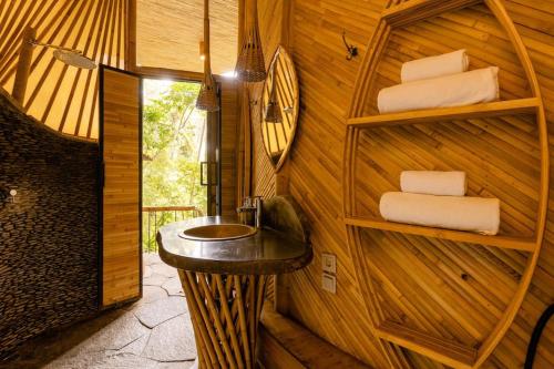 a bathroom with a sink in a wooden wall at Aura House 2bds Eco Bamboo House, Pool, River View in Bringkit