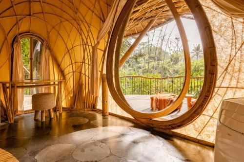 a round room with a large round window in a yurt at Aura House 2bds Eco Bamboo House, Pool, River View in Bringkit