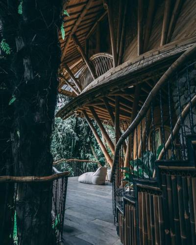 a building with a wooden ceiling and a tree at Aura House 2bds Eco Bamboo House, Pool, River View in Bringkit