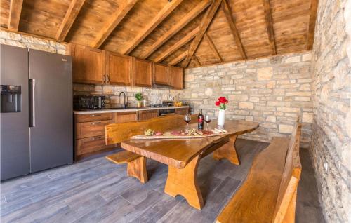 a kitchen with a wooden table and a refrigerator at Lovely Home In Perusic Donji With Wifi in Dušić