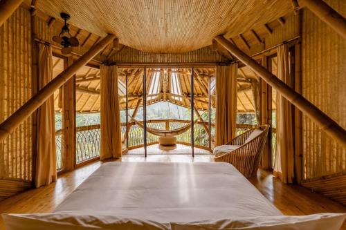 a large room with a bed and a window at Aura House 2bds Eco Bamboo House, Pool, River View in Bringkit