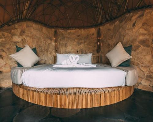 a bedroom with a bed with a towel on it at Aura House 2bds Eco Bamboo House, Pool, River View in Bringkit