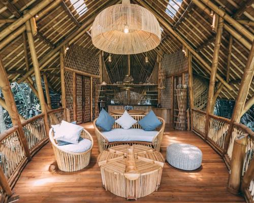 a living room with chairs and a chandelier at Aura House 2bds Eco Bamboo House, Pool, River View in Bringkit