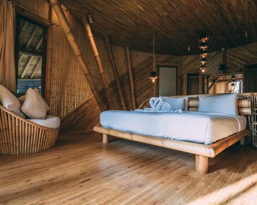 a bedroom with a large bed and a couch at Aura House 2bds Eco Bamboo House, Pool, River View in Bringkit