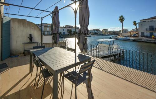 une table et une chaise sur un balcon avec une rivière dans l'établissement Cozy Home In Aigues-Mortes With Wifi, à Aigues-Mortes