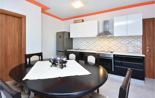 a kitchen with a black table and a black refrigerator at Gorgeous Home In Solin in Solin