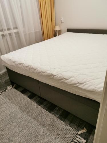 a bed in a room with a white mattress at Jaama Apartment in Valga